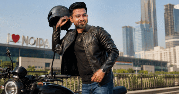 Confident man removing a biker helmet in Noida climate, showing flexible hair taping bond - Hair Taping in Noida